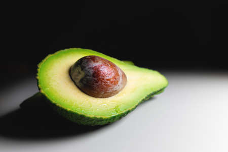Avocado on old wooden table.Halfs on wooden bowl. Fruits healthy food concept.の写真素材