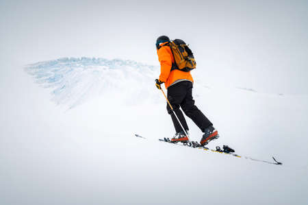 Winter skitour freeride in cloudy weather, snow-capped mountains