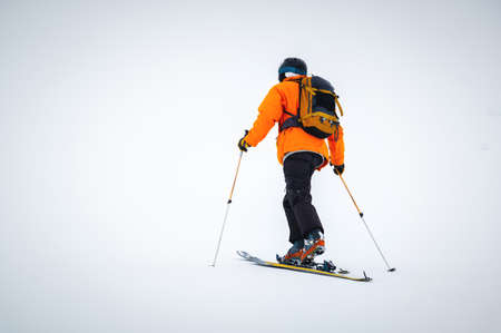 Winter skitour freeride in cloudy weather, snow-capped mountains