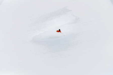 one freeride skier skiing downhill trough deep fresh powderの写真素材