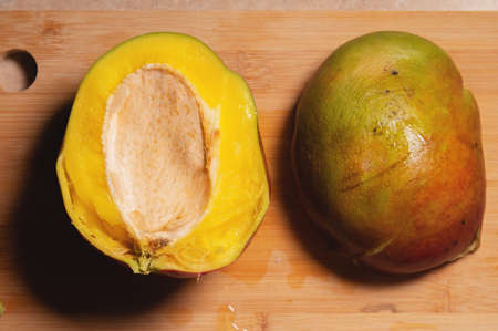Mango fruit cut into two halves. Not a beautiful image of a cut mango at home