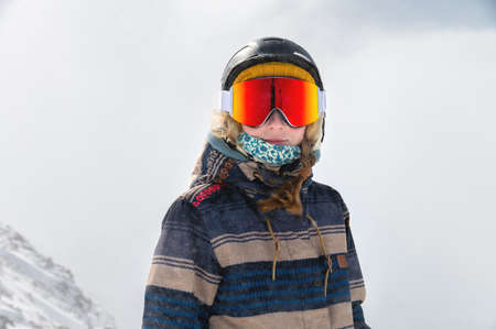 Macro portrait. Young adult woman, snowboarder or skier in a snowy winter on a mountain slope