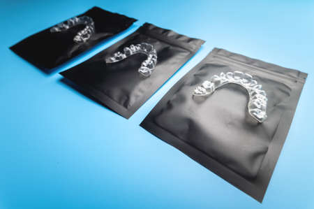Plastic invisible aligners lie of the package on a blue backgroundの写真素材