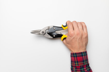 hand of a male craftsman firmly hold a construction tool on a white background, a template for a bannerの写真素材