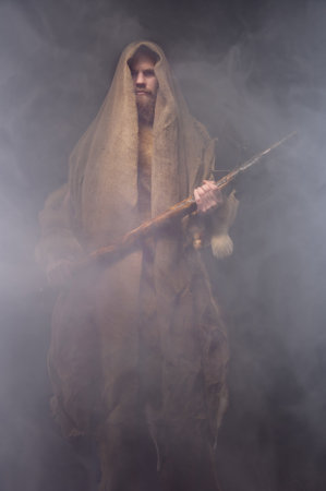 man in a vintage monk costume with a wooden ax in a haze, cosplay for ancient times, a historical plotの写真素材
