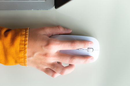 Close-up woman searching and clicking mouse using laptop, online shopping concept. Blurred backgroundの写真素材