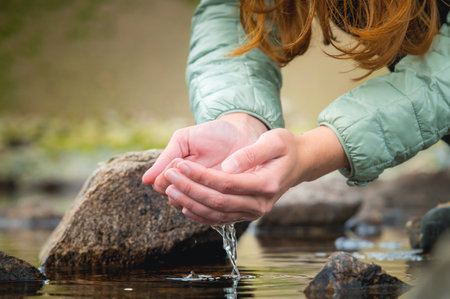close-up of hands scooping up fresh clear water. mountain lake or river