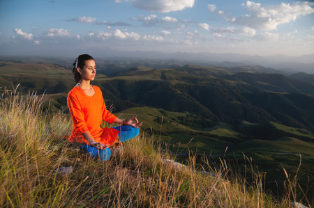 Attractive woman doing yoga. Healthy lifestyle. Woman doing yoga in the mountains. Girl doing yoga at sunrise. Woman meditates in nature. Meditation in the mountainsの写真素材