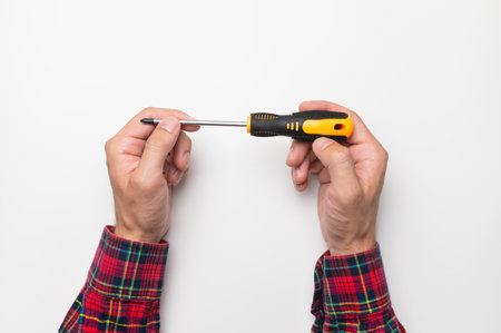 screwdriver in a male hand on a white background, top view. layout for text, phrases, inscriptionsの写真素材