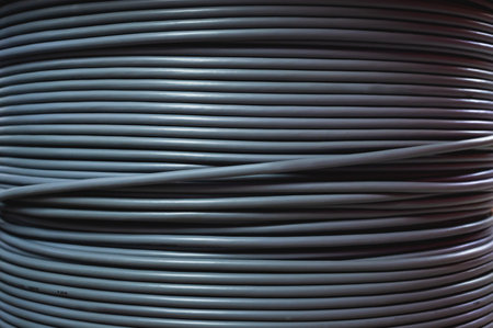 Close-up of a cable bay. Coiled cable in a polymer winding in a storage warehouse of a manufacturing...