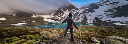 Beautiful mountain landscape with a lake and an emotional man. Sports extreme. The traveler man...