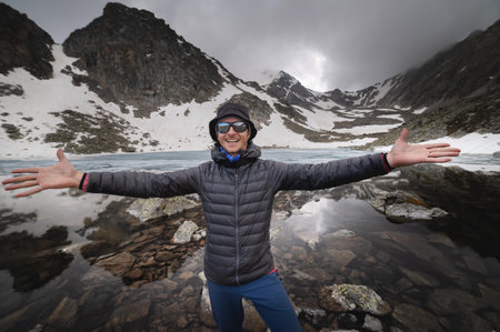 Young strong man with open arms looking at the camera. People feel good, happy and free in the...