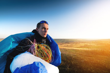 guy holds the lines of a paraglider in his hands close-up. A male paraglider carries a paraglider to...