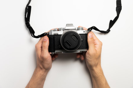 Photographer with camera on white background, close-up of hands and professional photo cameraの写真素材