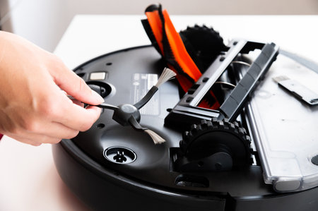Black robot vacuum cleaner on the table in the living room or in the office. Cleaning the apartment...