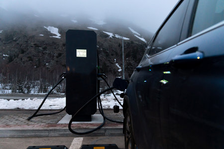 Using a charging station. Renewable energy concept. Electric car using sustainable source. Saving,...