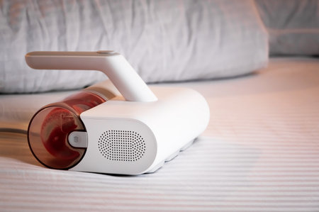 Specialized vacuum cleaner for removing linen mites and disinfecting bed linen and bedding. Vacuum cleaner with UV lamp on the bedの写真素材