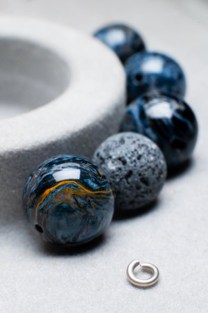 Close-up of beads for bracelet on gray background. Beautiful beads of blue and light blue colorsの写真素材