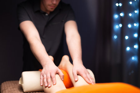 Hand of professional massage therapist, foot massage with oil, preparing clients feet for massage in health spa center. Foot massage conceptの写真素材