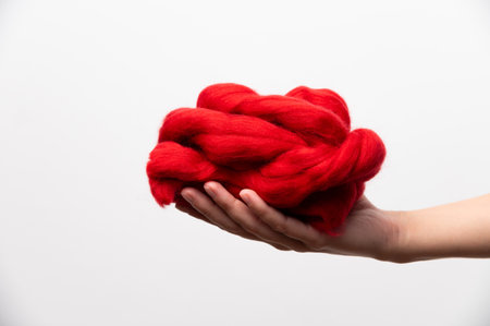 Woman holding red or orange wool ewes in knitting yarn on white background, Copy space. Hobby knitting conceptの写真素材