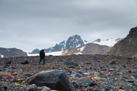 Man walking through snowy desert landscape. Mountain tourism in any weatherの写真素材