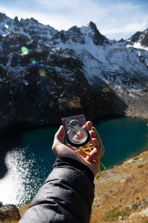 Mountain range and tourist hand with compass on foreground. Nature reserve, travel concept. Landscape photographyの写真素材