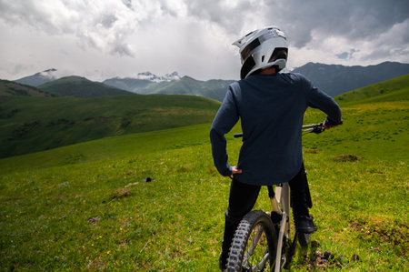 Male athlete cyclist in helmet and protective mask outdoors. MTB rider in mountainous terrain against the backdrop of epic rocks.の写真素材