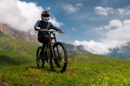 Male athlete cyclist in helmet and protective mask outdoors. MTB rider in mountainous terrain against the backdrop of epic rocks.の写真素材