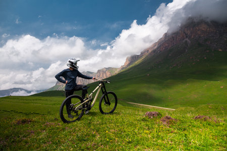 Male athlete cyclist in helmet and protective mask outdoors. MTB rider in mountainous terrain against the backdrop of epic rocks.の写真素材