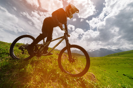 Male athlete cyclist in helmet and protective mask outdoors. MTB rider in mountainous terrain against the backdrop of epic rocks.の写真素材
