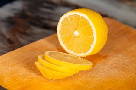 Close-up of lemon slices on a wooden cutting board. Nobody, lemon prepared for adding to a dish or for lemon waterの写真素材
