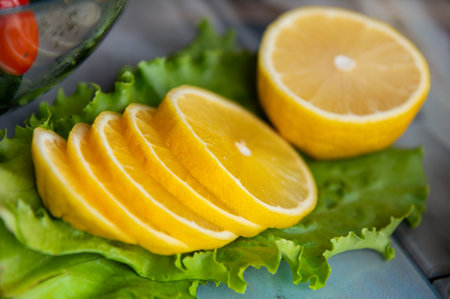 Sliced lemon lies on green lettuce leaves, product preparation. Nobody, view from aboveの写真素材