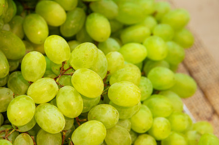 A bunch of white grapes lies on the counter in a vegetable store