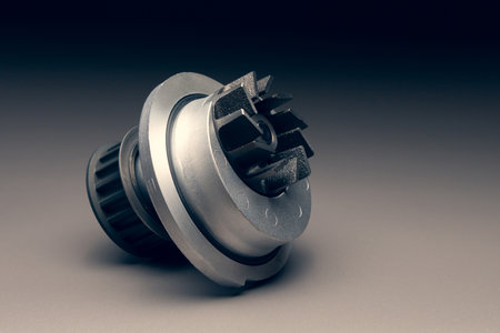 A new car part on a gradient gray background. Close-up of a new internal combustion engine coolant...