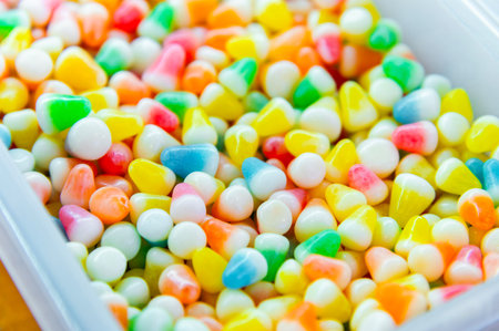 Pile of colorful glazed dragees. Shiny candies in a sugar crust. A background of glazed or...