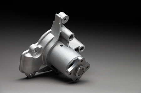 A water pump for a cars cooling system on a black gradient background. The water pump circulates...
