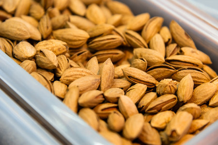 Close-up of unpeeled almonds lying in a bowl on a store counterの写真素材