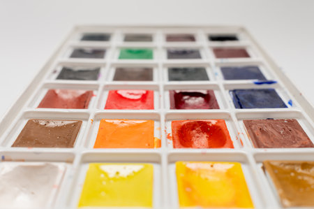 A set of used bright watercolor paints on a white background. Close-up macroの写真素材