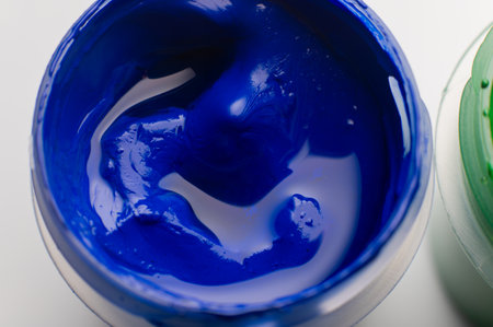 macro shot of open plastic containers filled with colorful acrylic paints. The art supplies feature vibrant pigments, a shallow depth of field, and a blurred backgroundの写真素材