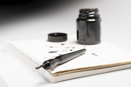 stylish fountain pen on paper with ink drops and a side view of the ink tank. Space for text