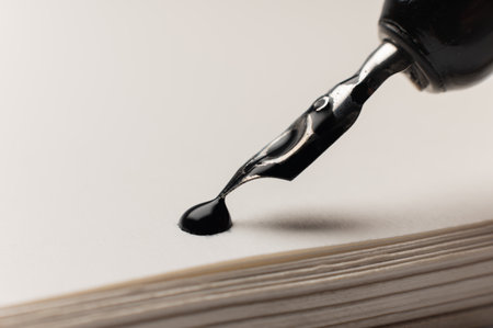 A close-up macro shot of a drop of ink on a notepad. A fountain pen is nearby. Retro office concept.の写真素材