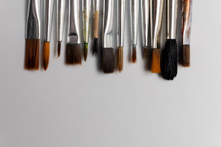 Close up of a group of artist brushes on a white table. The brushes are of different sizes and materials. Art suppliesの写真素材