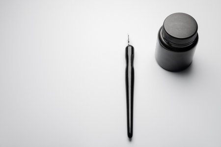 Modern fountain pen with ink bottle on white table, top view, space for text and advertisementの写真素材