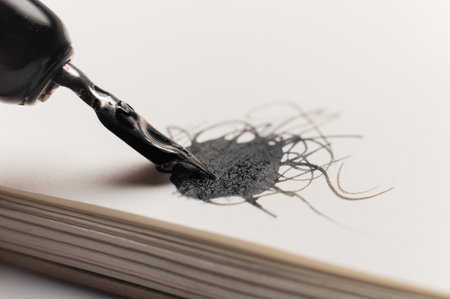 macro shot of a black abstract blob with lines and a fountain pen drawing the blob. A strange ink drawingの写真素材