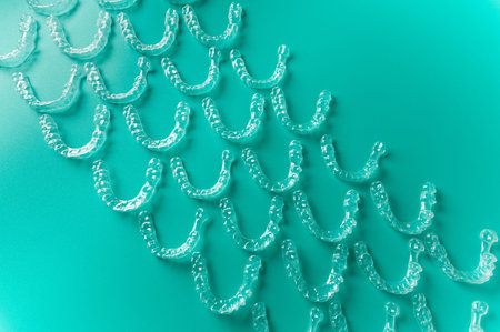 Clear aligners and braces on a colored background. Many clear braces on a colored background. Dental...