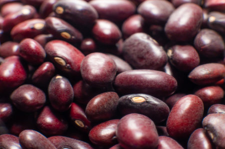 A close-up of a large amount of red kidney beans in a clear storage jar. Macro shot of the beans...