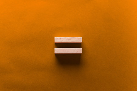 Two wooden blocks arranged horizontally on a vibrant orange background, showcasing a minimalist...