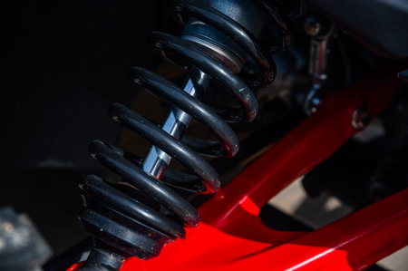 Close-up of automotive shock absorber with coil spring and red frame