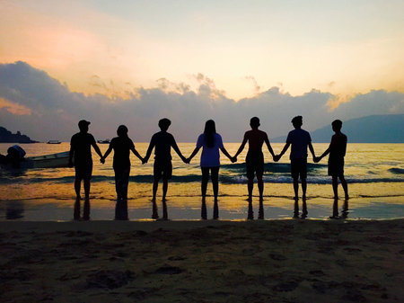 Group of friends holding hands in silhoutteの素材