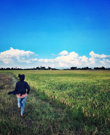 Women running on paddy fieldの素材